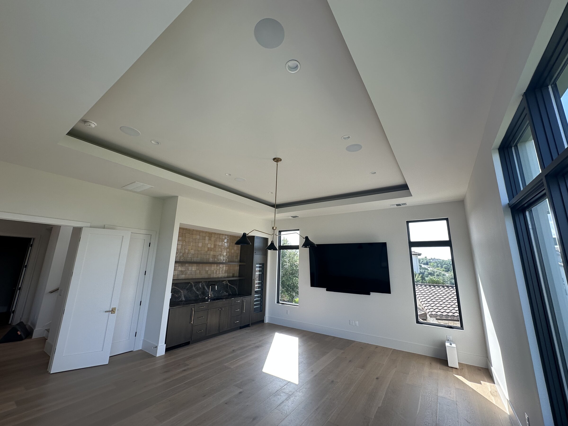 Vaulted great room with integrated ceiling speakers and a wall-mounted television